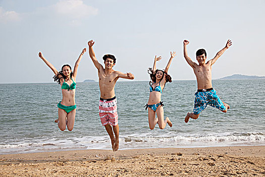 青年人在沙滩上跳跃