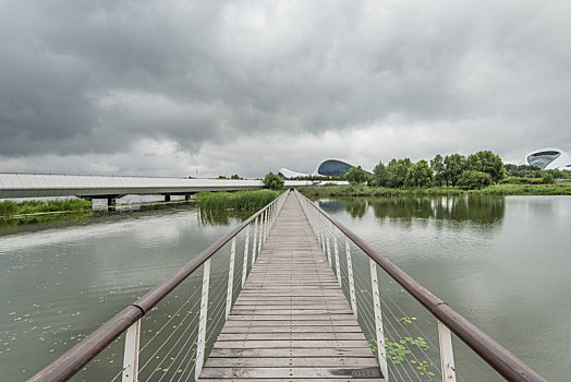 多云天气下湖边建筑绿地栈桥