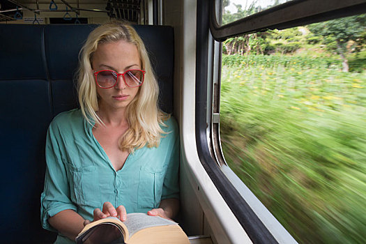 金发,白人女性,读,书本,列车,窗户