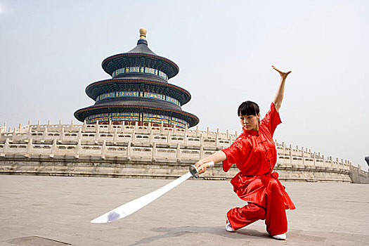 中国武术--一名女武术运动员在天坛祈年殿前练刀法