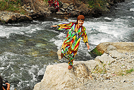 tajikistan,penjakent,portrait,of,local,girl,in,traditional,dress,playing,by,the,river