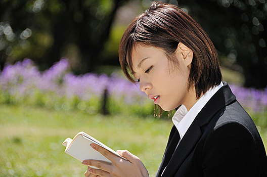 年轻女性在公园里读书