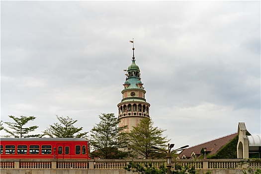 多云天户外拍摄驶过欧式建筑的轻轨电车