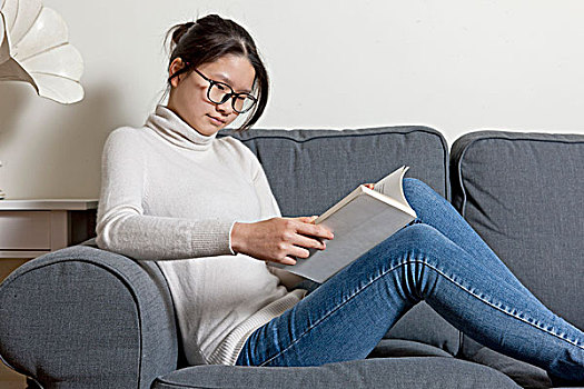 女孩在沙发上看书