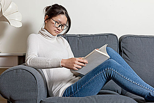 女孩在沙發上看書