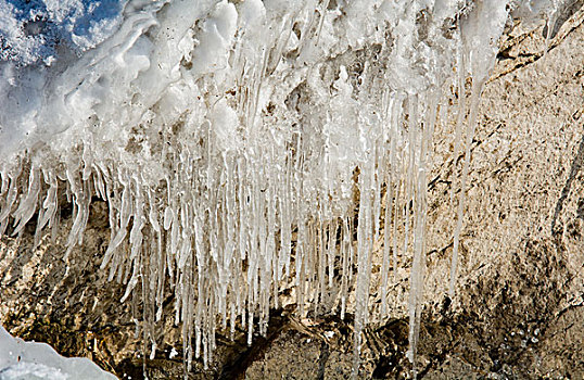 冬天湖边石头上结冰的冰柱