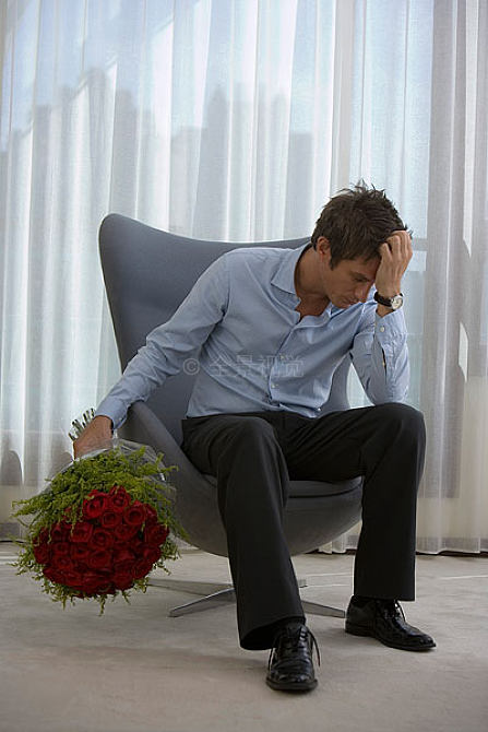 一位手捧鲜花垂头丧气的先生