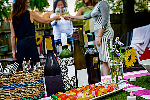群体,女人,花园派对,拿着,葡萄酒杯,制作,干杯,葡萄酒瓶,桌上,前景