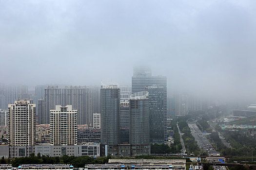 山东省日照市,海边冷暖空气交汇,云雾变化多端环绕百米高楼