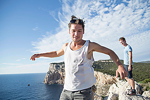 男青年,戴着,背心,悬崖,海洋,展开双臂,跳跃,姿势,萨丁尼亚,意大利