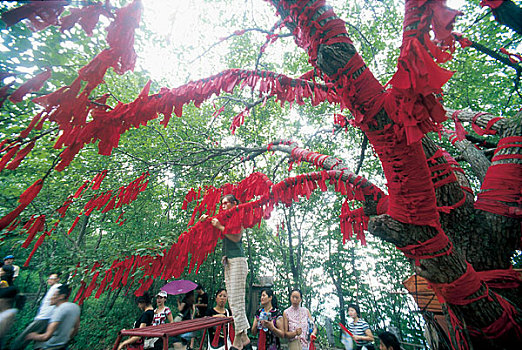 辽宁本溪桓仁县五女山城的游客在山上的树上系红布条以祈福