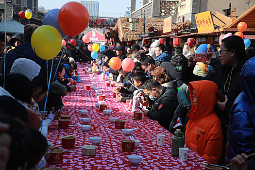 小镇摆下百米长桌宴,市民游客新年吃饺子交好运