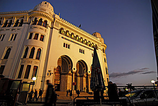 algeria,alger,low,angle,view,of,people,by,post,office,building,against,sky,at,dusk