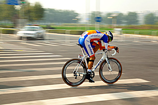 骑着公路自行车在公路上进行比赛的白人选手