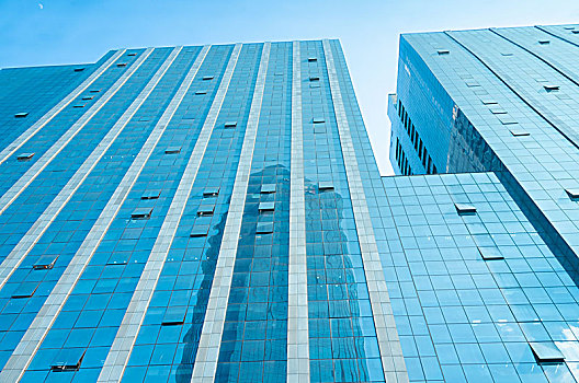 蔚蓝色的天空下的高楼建筑玻璃外立面