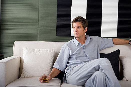 一个穿着休闲装的男人坐在沙发上看着镜头