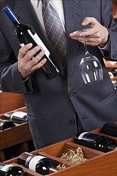 商务人士,拿着,葡萄酒瓶,葡萄酒杯