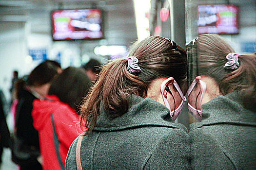 疲惫的女子在地铁站台边等待列车的到来,北京