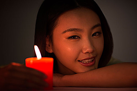 年轻女性拿着红蜡烛