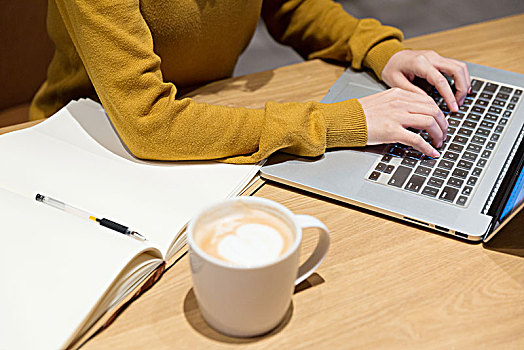在咖啡馆里喝咖啡上网工作特写
