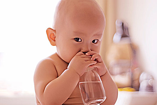 注视镜头抱着奶瓶的婴儿