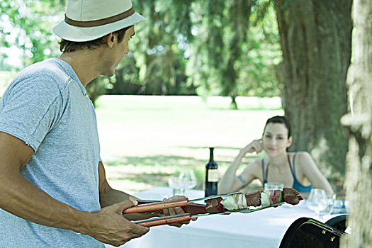 男人,拿着,烤串,转,坐,女人,野餐桌