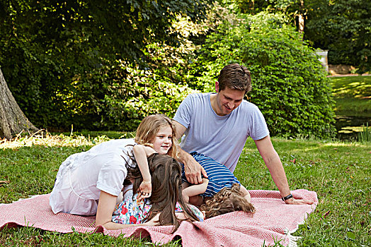 中年,父母,两个,女儿,弯曲,向前,野餐毯,公园