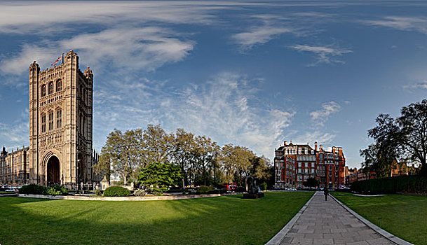 蓝天白云下坐落在绿色草地上的具有欧洲风格的英国伦敦塔和一栋古典建筑