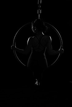 东方女子练习空中瑜伽黑色光影效果空中瑜伽