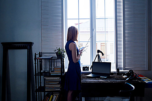 中年,女人,站立,旁侧,窗户,智能手机,摄影,笔记本电脑,桌上