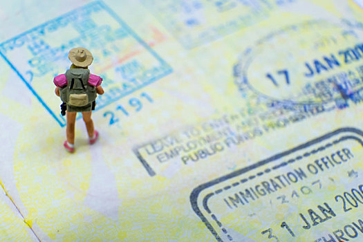 一名女背包客走在护照内页的出入境印章上