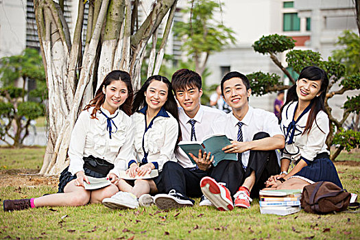 五个大学生在草地上读书