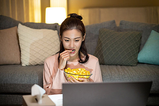 年轻女士在家吃使用电脑