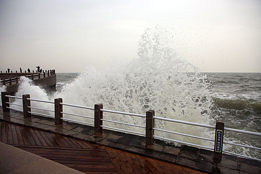 山东省日照市,灯塔风景区风大浪高,游客冒雨观赏浊浪排空奇观