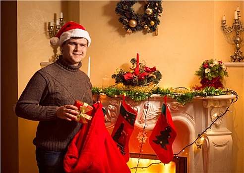 微笑,男人,放,礼物,圣诞袜,悬挂,壁炉