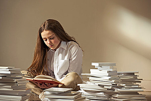 女孩,坐在地板上,读,围绕,堆放,书本