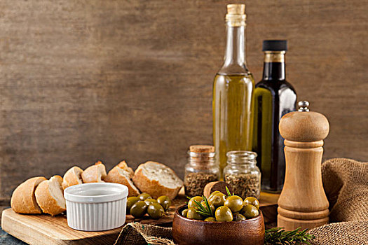 橄榄,胡椒摇瓶,油瓶,面包,桌上,墙壁