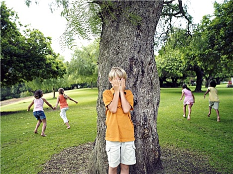 男孩,7-9岁,捂眼,玩,捉迷藏,公园,隐藏,朋友,后面,树
