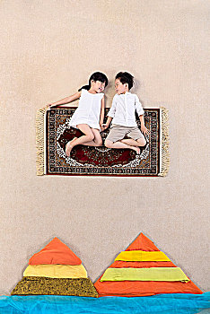 坐在毯子上的两个小孩