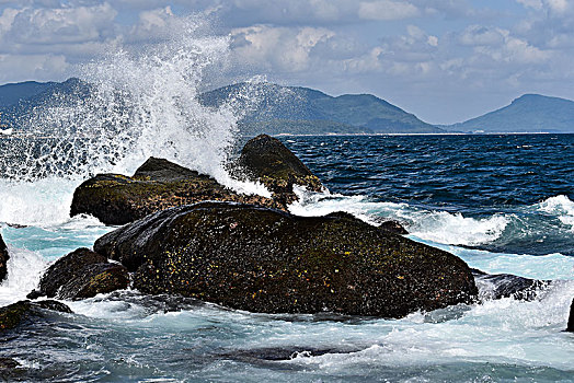 海浪拍打岸边黑色的礁石