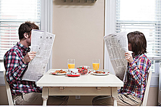 年轻,情侣,读,报纸,厨房用桌