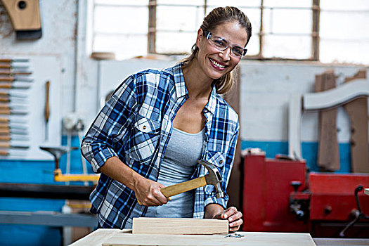 女性,木匠,拿着,锤子,钉子,厚木板,工作间
