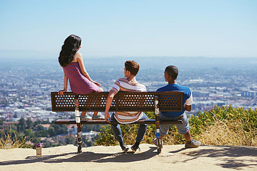 三个,年轻人,朋友,向外看,城市,山顶,长椅,后视图,洛杉矶,加利福尼亚,美国
