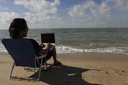 后视图,男人,坐,海滩,工作,笔记本电脑