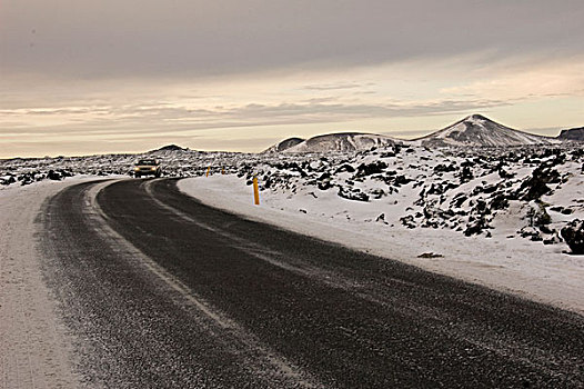iceland,blue,lagoon,road,along,color,lake,with,snowy,lava,rock,in,the,background