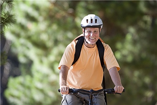 老人,橙色,t恤,自行车头盔,山地车,树林,小路,微笑,正面,头像