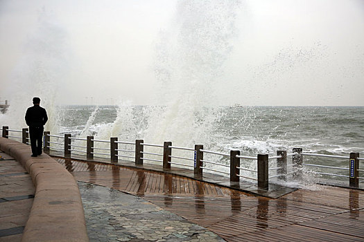 山东省日照市,灯塔风景区风大浪高,游客冒雨观赏浊浪排空奇观