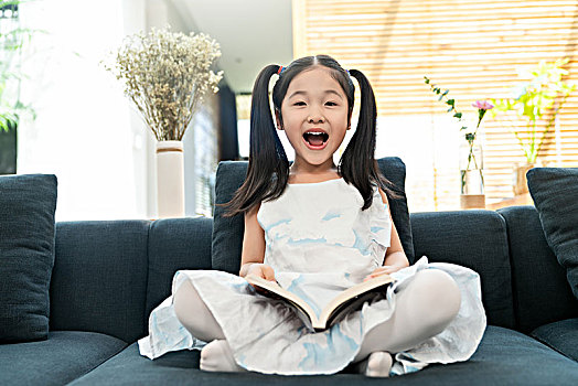 小女孩在沙发上看书
