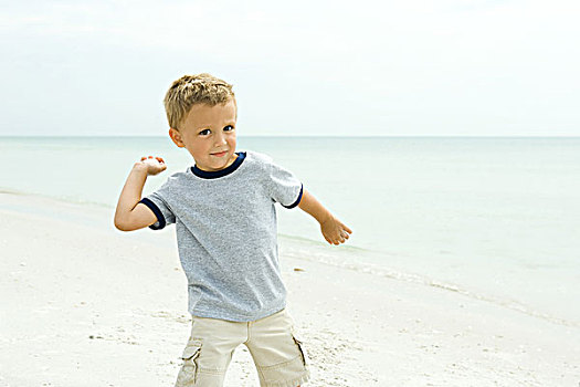 男孩,海滩,投掷,海贝,看镜头,微笑