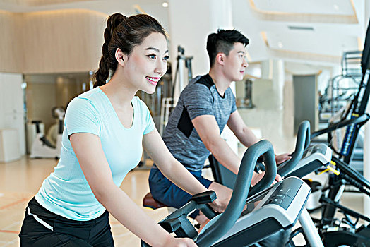 年轻男子和女子在健身房健身
